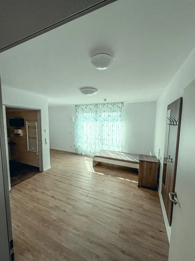 Wohnlich eingerichtetes Einzelzimmer mit modernem Pflegebett und behaglicher Atmosphäre in der Intensivpflege-WG Lohne