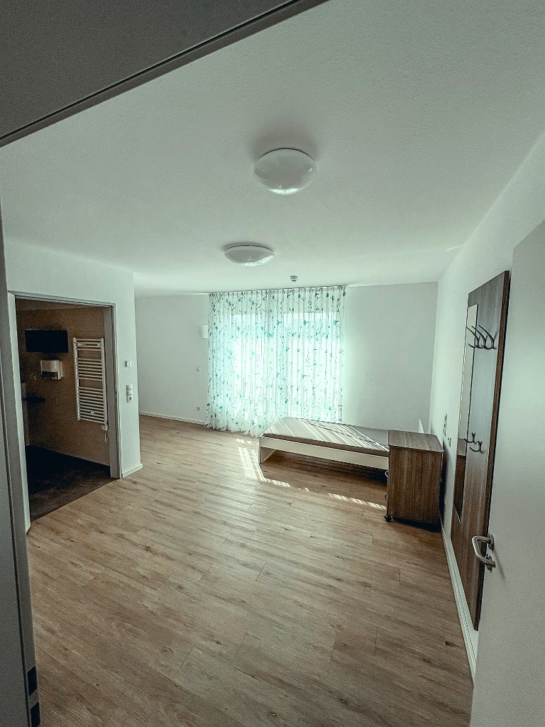 Wohnlich eingerichtetes Einzelzimmer mit modernem Pflegebett und behaglicher Atmosphäre in der Intensivpflege-WG Lohne