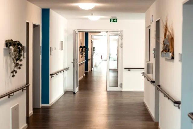 Lichtdurchfluteter Flur mit verglasten Elementen und barrierefreiem Durchgang zu den Wohnbereichen
