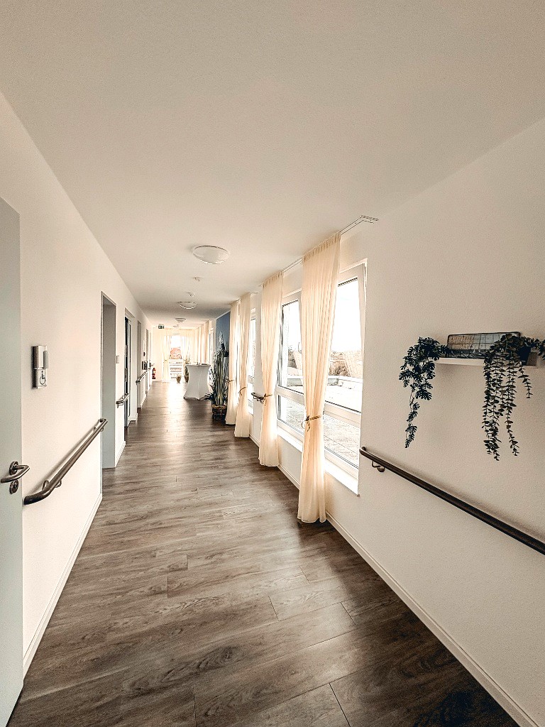 Heller, weitläufiger Flur mit großen Fenstern und natürlichem Tageslicht im oberen Gebäudeteil