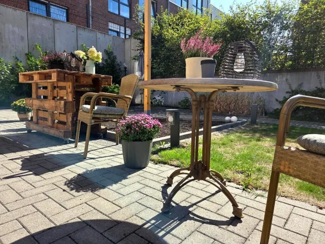 Sonnige Gartenterrasse mit gemütlichem Sitzbereich und grüner Parkanlage im Seniorenhaus Lohne