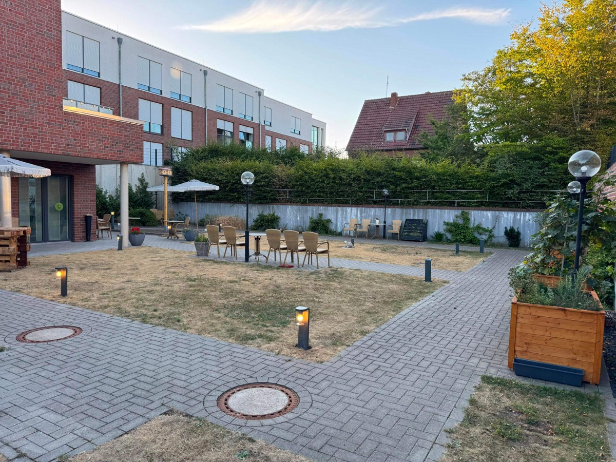 Gepflegter Garten und Innenhof der Pflegeeinrichtung Seniorenhaus Lohne mit grünem Sitzbereich