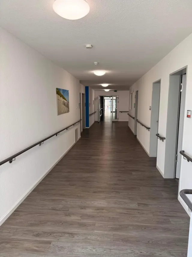 Heller, barrierefreier Flur mit beidseitigen Handläufen im Altenpflegeheim Lohne