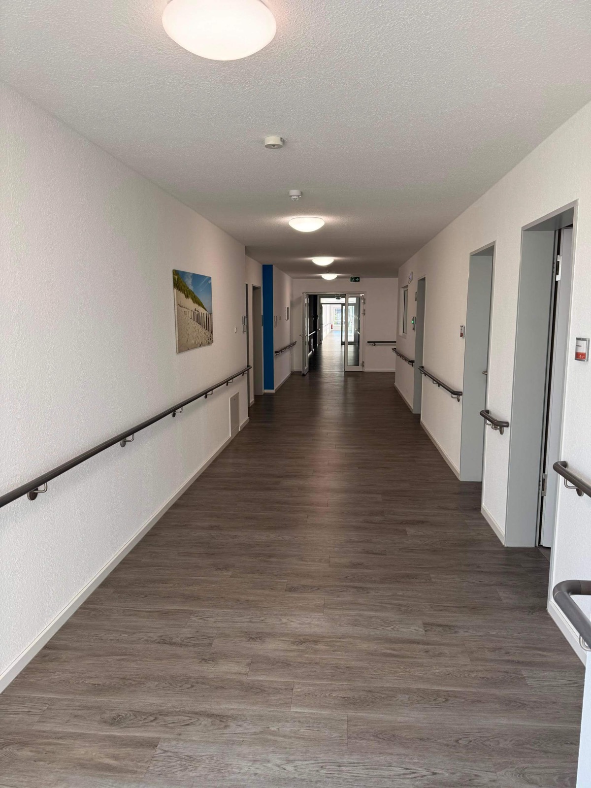 Heller, barrierefreier Flur mit beidseitigen Handläufen im Altenpflegeheim Lohne